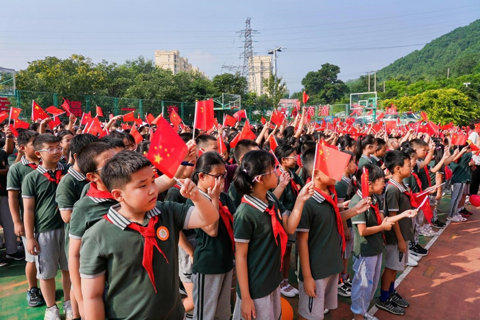 京师实验小学的学生们手持红旗，满怀激情参与立志礼