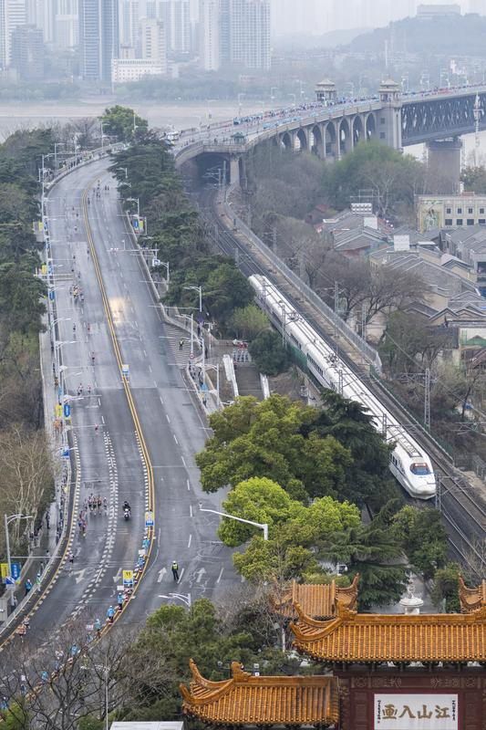 3月23日，武汉马拉松参赛选手经过黄鹤楼。新华社记者 伍志尊 摄