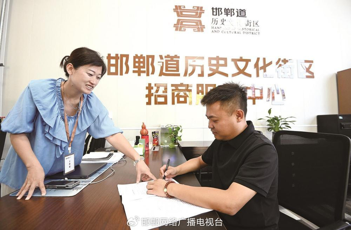 邯郸道历史文化街区招商服务中心的工作人员和商户签约。邯郸新闻传媒中心记者 郝群英 摄