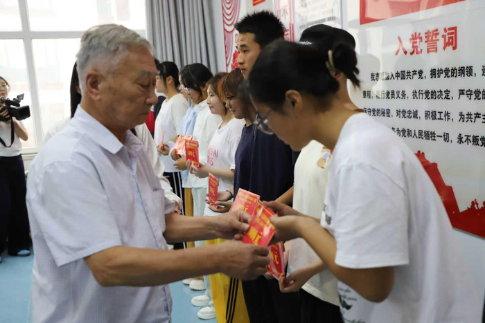 丁道昌為受資助的學(xué)生發(fā)放獎學(xué)金。