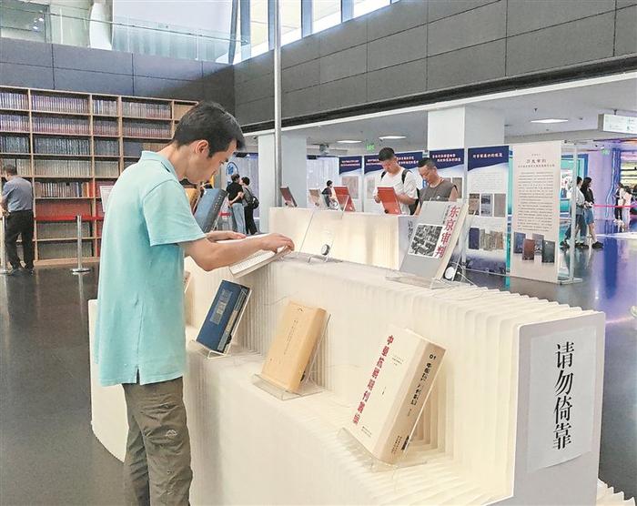 近日，＂让历史说话 用史实发言——国家图书馆抗战文献整理成果展＂在国家图书馆举办。图为观众在阅读展出的抗战文献。