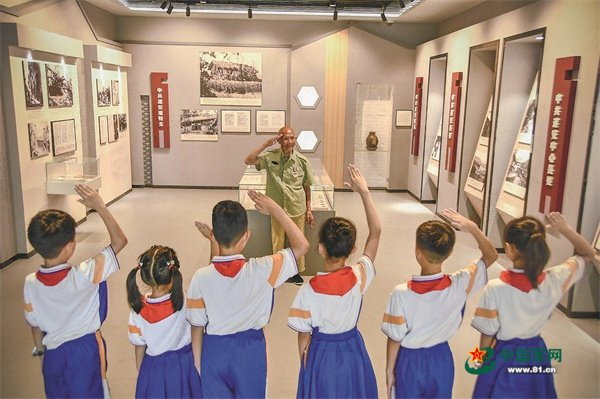 　　岳石小学学生向抗战老兵吴绍卿行少先队队礼。贾祥龙摄