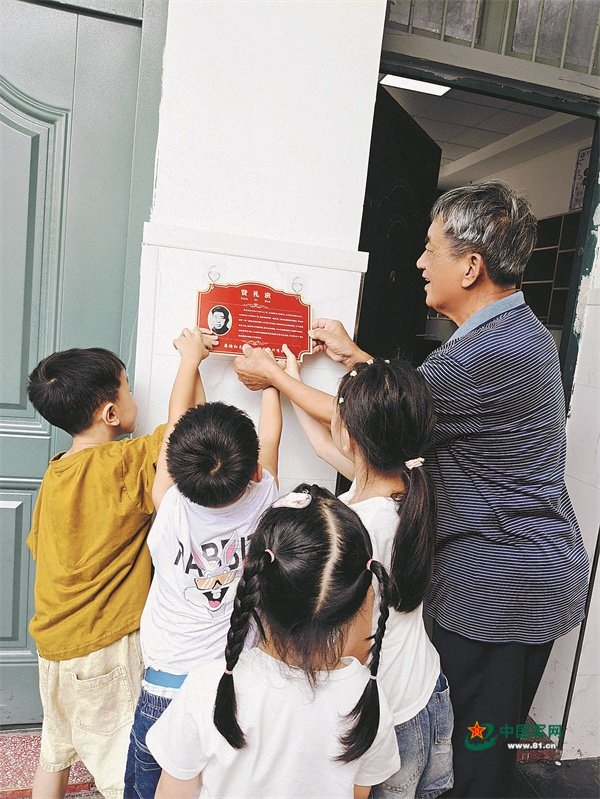 　　蒋贤礼烈士的儿子蒋义生，与楂林小学“贤礼班”学生一起挂“英烈牌”。季俊磊摄