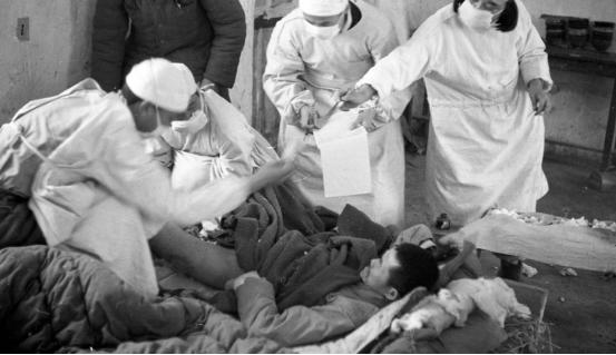 资料图:1950年12月,医生和护士在给作战负伤的伤员治疗。