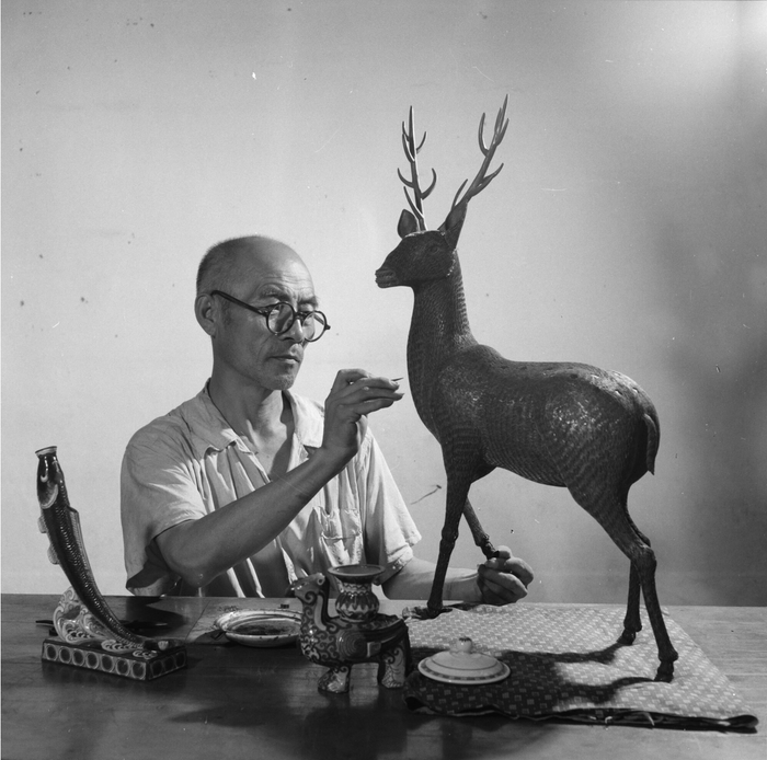 1961年，北京工艺美术厂景泰蓝老艺人金世权在精心创作新作品梅花鹿。 高宏摄