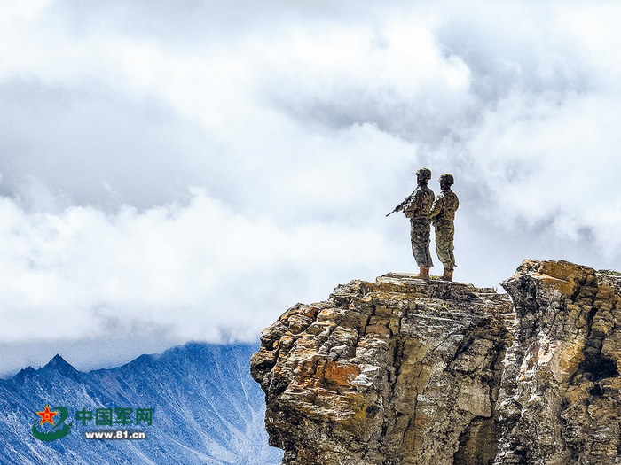  抵达目标点位后，临退役老兵杨海勇(左)带领新兵孙小辉观察点位周边情况。解放军报特约记者  陈武斌摄