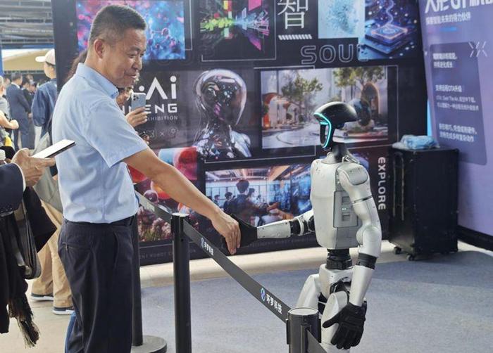 图为参观者与机器人互动