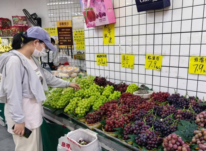 近日，济南历下区一家水果店内，消费者正在选购葡萄。