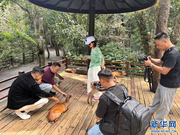 采风团成员与动物亲密互动并记录瞬间（9月16日摄）。新华网发（张玛睿 摄）