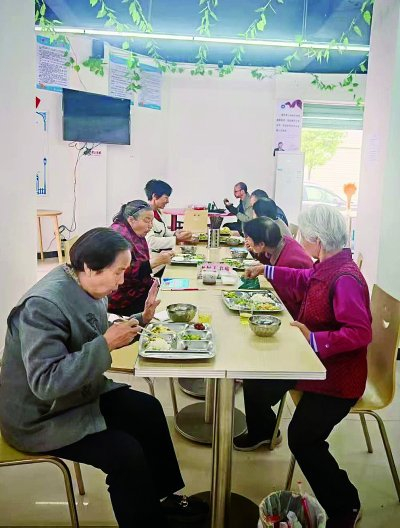     社区老人在共享餐厅用餐。