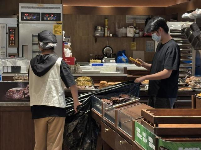 百联又一城的熊治面包，店员正在丢弃当日未售出面包