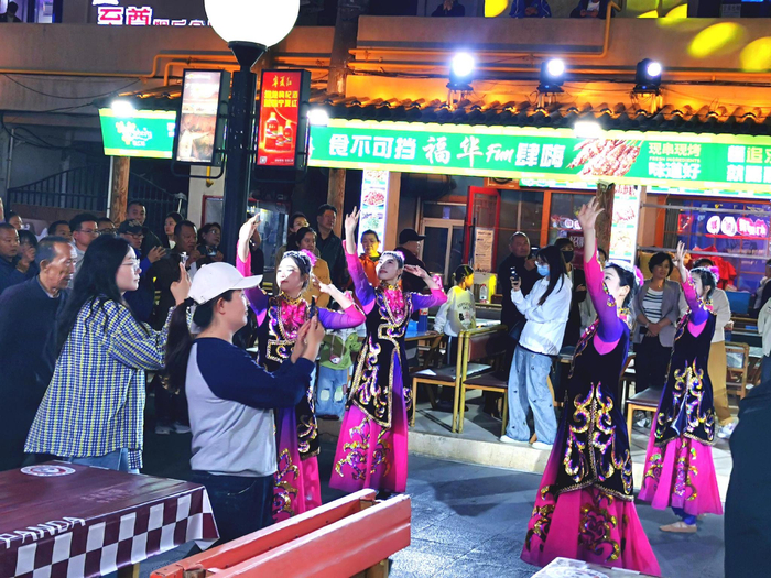 演员们边舞边走，游客们边跟边拍。