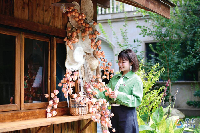 山水边美学庭院餐厅里，设计师陈果苹正在为院子更换装饰品（彭红霞摄）