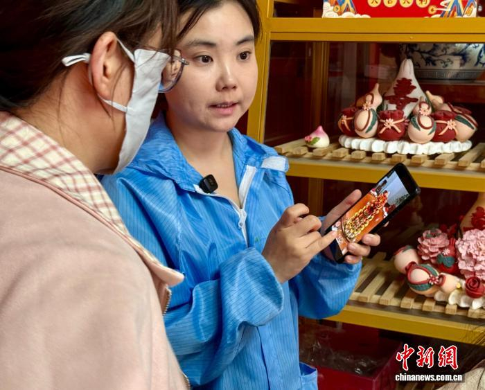 马瑞(右)正在为顾客介绍店里的花饽饽。王牧雨 摄