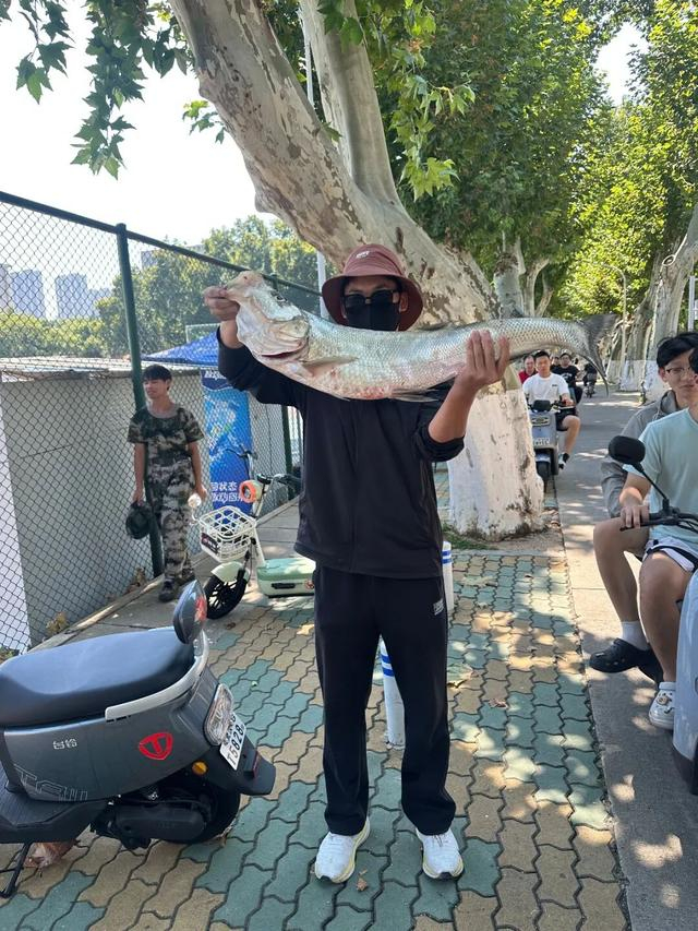 周同学和鱼的合影。图/受访者提供 