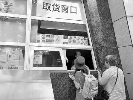 　　顾客在味多美工厂店窗口取货。实习记者 宋雨迪 摄