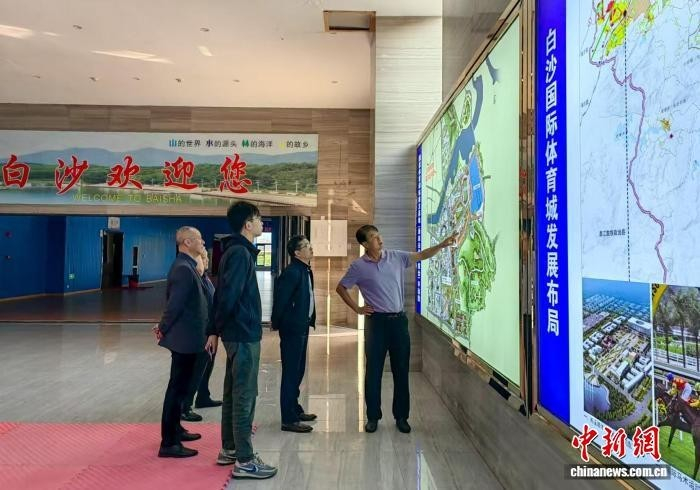 图为海南家国文化体育有限公司董事长康闽利(左一)向来访者介绍白沙的文体资源。　(受访者 供图)