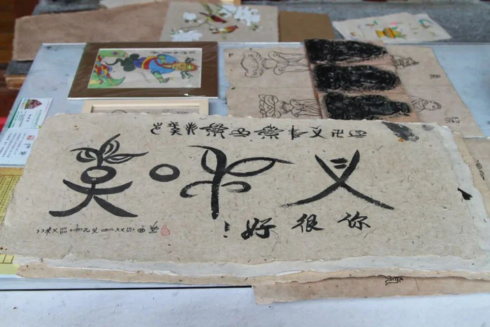 东巴纸上写着东巴文“好想你” 供图