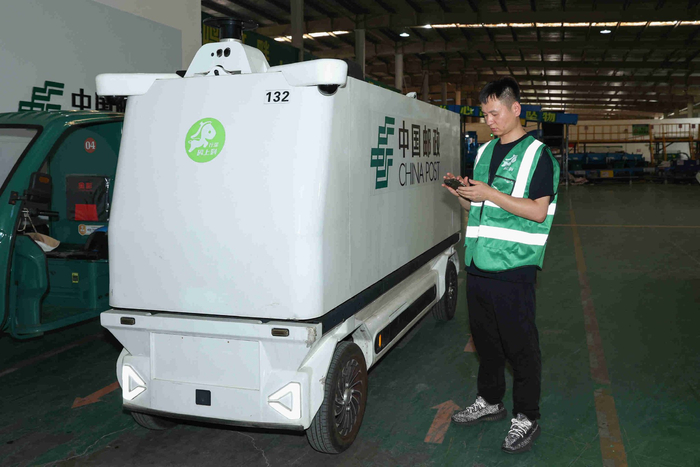 耿杰在调度无人快递物流车。人民网记者 张俊摄