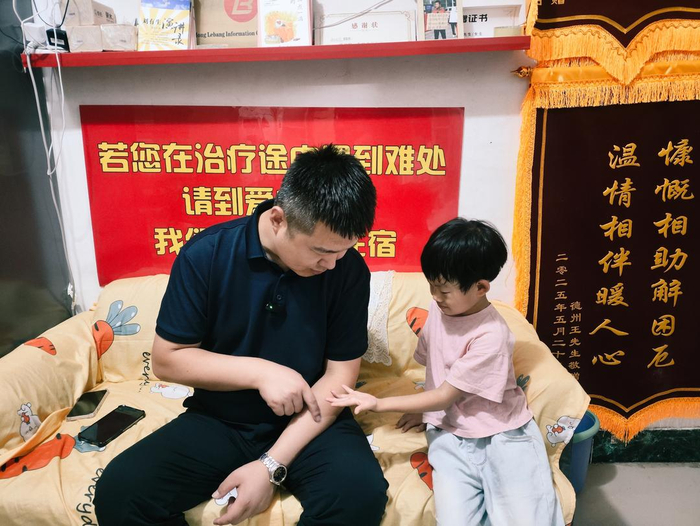郑刚和做完检查的患儿说笑