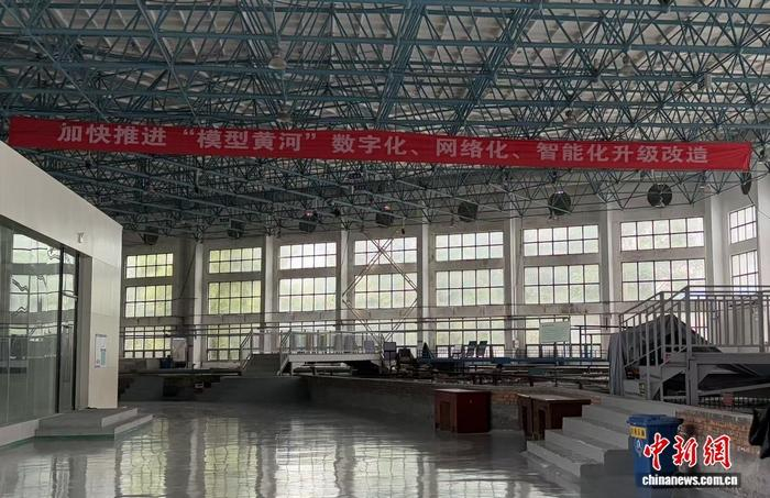    试验基地内挂着升级改造标语。 谢艺观 摄