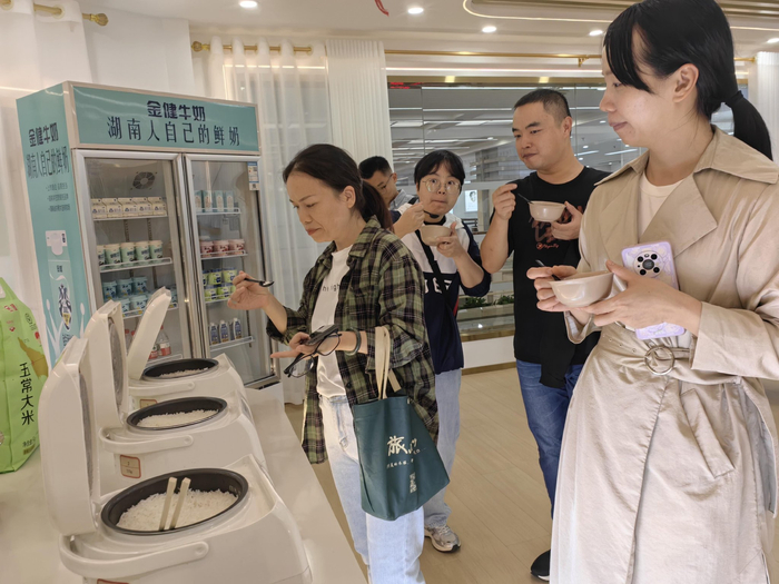 消费者在产品体验区品尝香喷喷的米饭。 余知都/摄