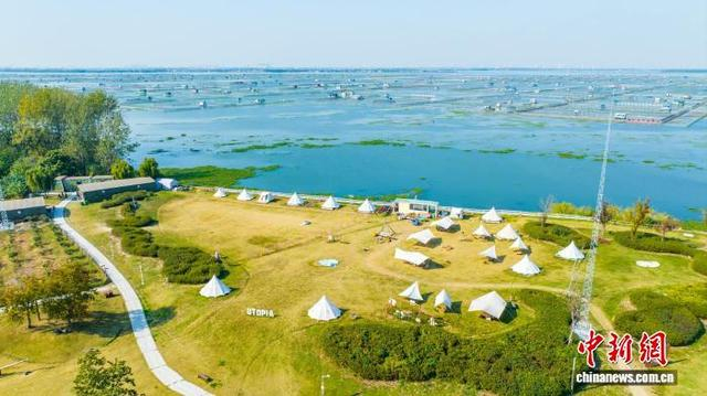 湖畔的露营地与湖中的大闸蟹养殖围网相得益彰。 巴城镇供图