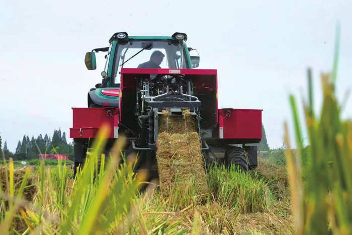 農(nóng)民駕駛打捆機(jī)進(jìn)行打捆離田作業(yè)。劉馨予攝