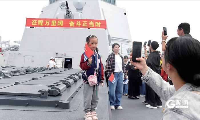 一名小军迷在战舰上拍照留念。
