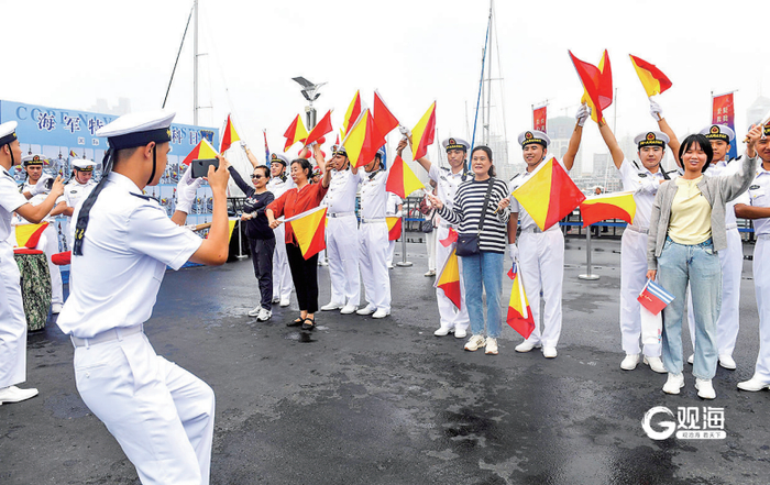 市民游客跟着海军战士学习旗语。