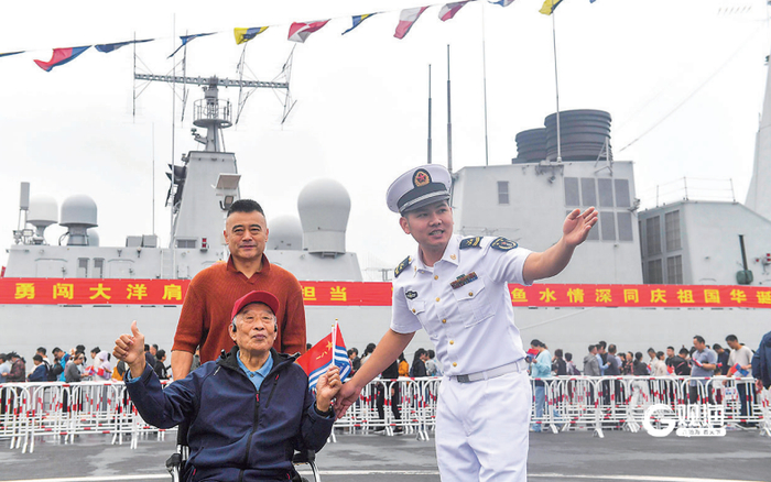 一名坐着轮椅的退伍老兵在参观中近距离感受现代化战舰风采。