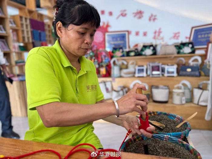 农芳莲动作娴熟利落地将茉莉花填入布囊。