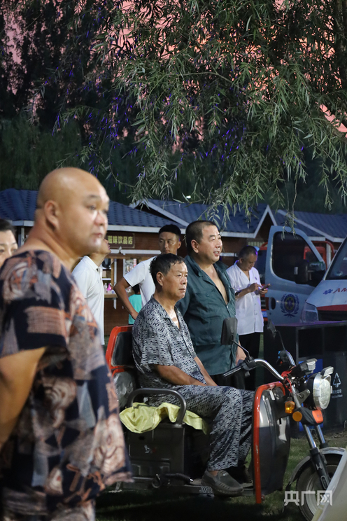 村民骑车到场边看球（央广网记者  王姝姝  摄）