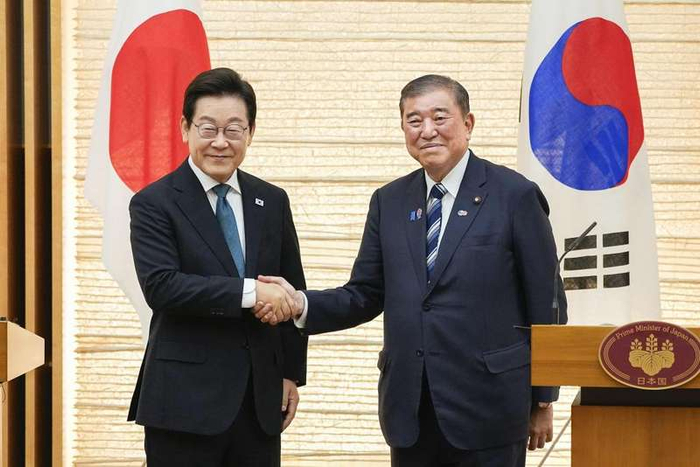 2025年8月23日，在日本东京，韩国总统李在明（左）与日本首相石破茂在共同记者会后握手。新华社/共同社