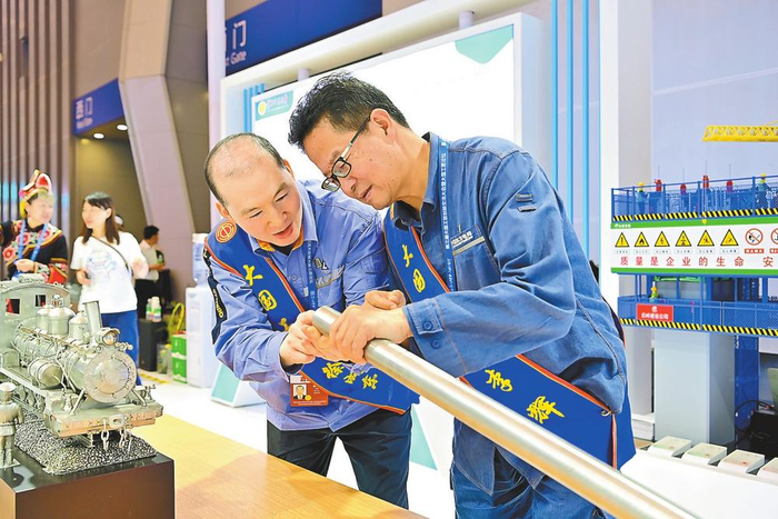 徐成东（左）与李辉（右）在交流技术问题。 通讯员 李恒 摄