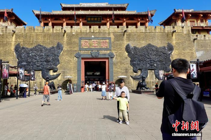 图为游客在景区门口打卡。中新社记者 刘子琳 摄