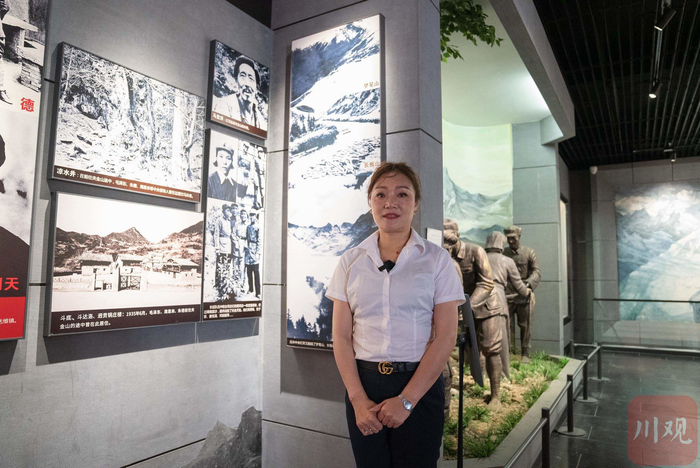 马花在宝兴县红军纪念馆，左上角的照片为他的爷爷马登洪