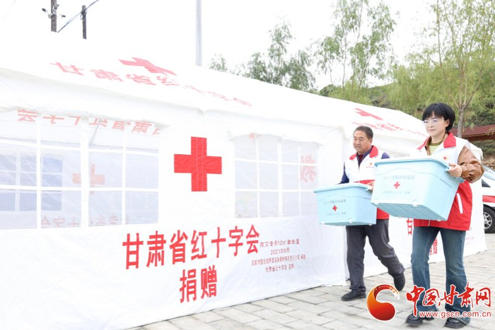 陇西县红十字会工作人员在临时安置点发放赈济家庭箱