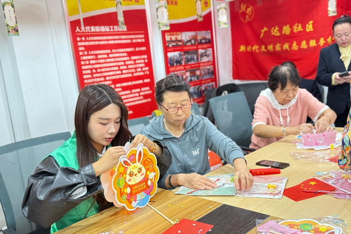 居民们在链家经纪人带领下制作玉兔灯