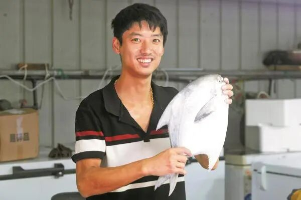 “海鲜小哥”沈恒旭展示其销售的鲳鱼。（陈章升 王林威 摄）