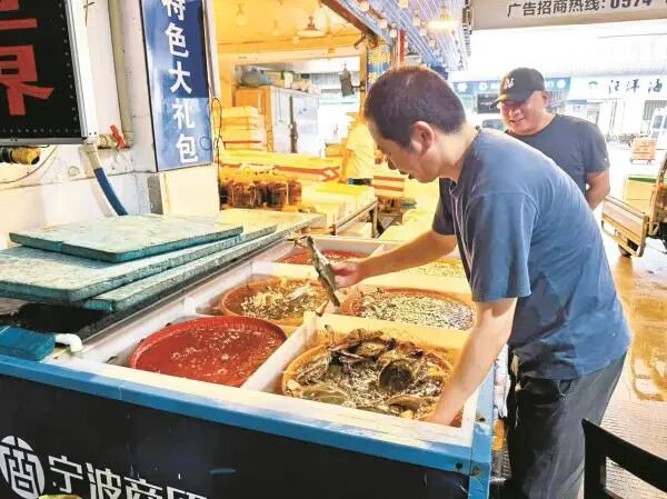 店主正在分拣梭子蟹。（王佳辉 摄）