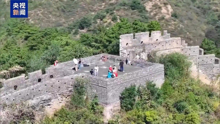 10月1日，游客在河北承德金山岭长城登高远眺，遥望群峰。图片来源：央视新闻