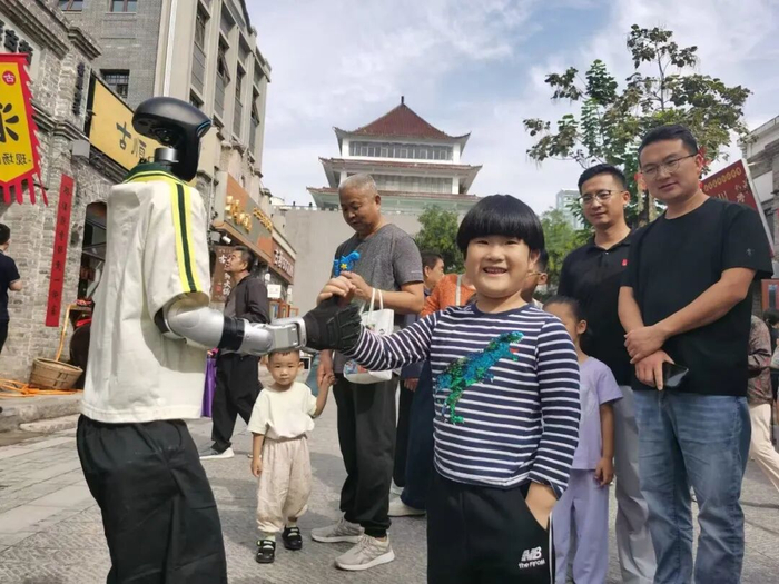 好南关街区，机器人和小朋友互动。黄涛摄