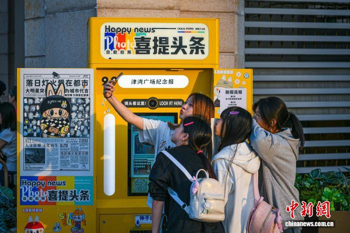 　　9月30日，天津津湾广场一处“拍报机”互动装置吸引众多市民游客驻足体验。中新社记者 佟郁 摄