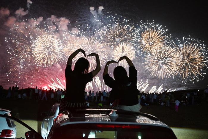 2025年8月10日，游客在宁夏中卫市沙坡头区观看烟花表演。新华社发（袁宏彦摄）