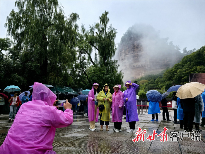 游客与“麦积烟雨”合影。新甘肃·甘肃日报记者 安东摄