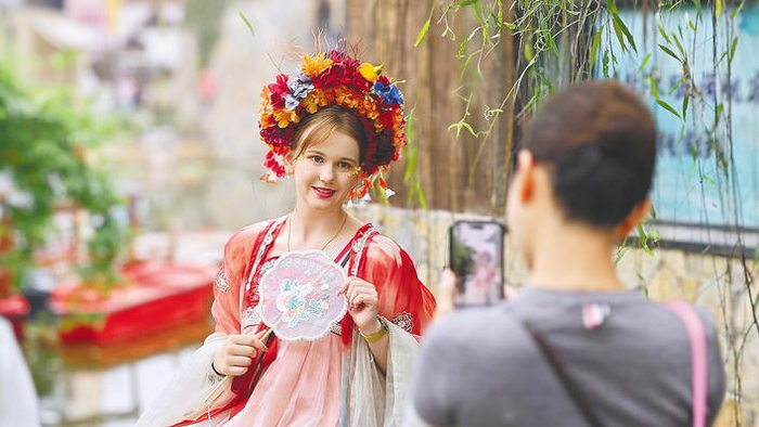 10月4日，一名外国游客在钟祥莫愁村执团扇、着汉服，浸润中国文化，定格古风瞬间。（湖北日报全媒记者 陈少哲 摄）