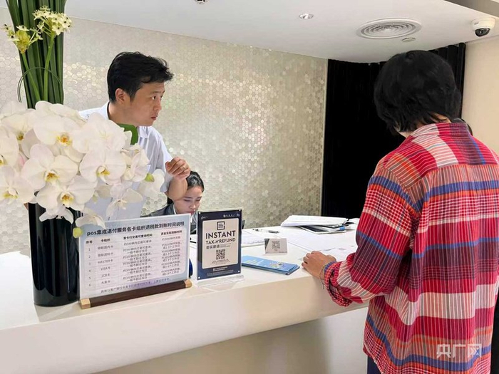 韩国游客（右一）正在办理离境退税 （央广网记者 沈梅摄）