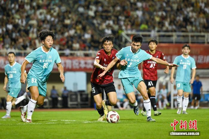 图为双方球员在比赛中拼抢。中新社记者 何蓬磊 摄