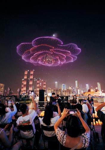 ▲10月1日，南岸区南滨路，人们正在观看“新韵重庆 长安同行”无人机灯光秀表演。特约摄影 郭旭